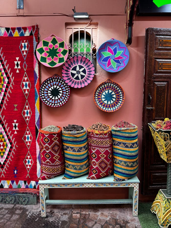 Vibrant market display in Marrakech showcasing colorful textiles and baskets with spices.
