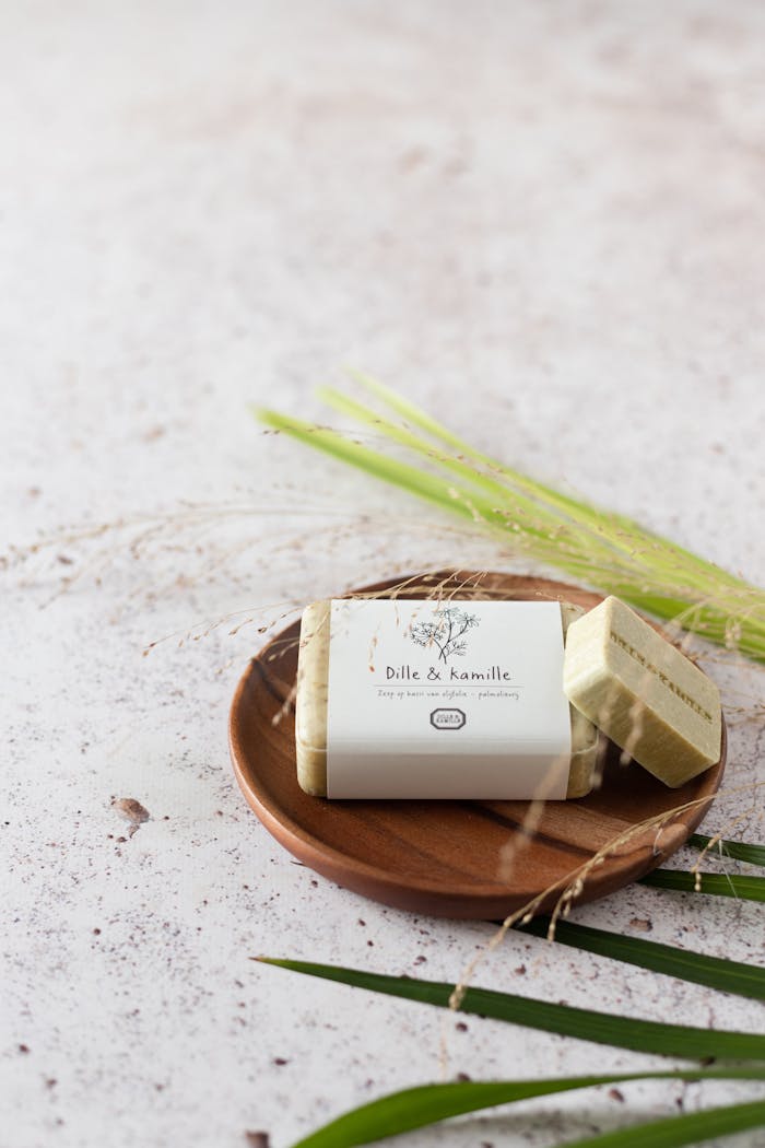 Organic soap bar displayed on a wooden plate with green leaves, perfect for eco-friendly branding.
